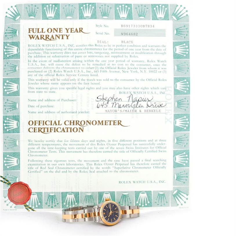 The image shows a Rolex Datejust 69173 Women's Stainless Steel Black Dial 69173 Women's Stainless Steel Black Dial watch positioned in front of its warranty and chronometer certification documents.