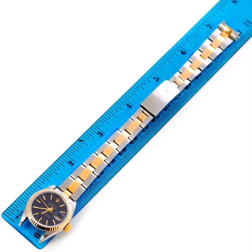 The image shows a Rolex Datejust 69173 Women's Stainless Steel Black Dial 69173 Women's Stainless Steel Black Dial watch laying flat beside a blue ruler, displaying its case, dial, and bracelet.