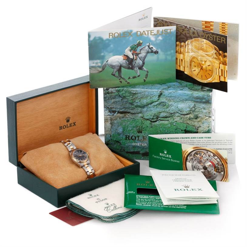 This image shows a Rolex Datejust 69173 Women's Stainless Steel Black Dial 69173 Women's Stainless Steel Black Dial watch, its box, and various booklets and accessories, viewed from the front.