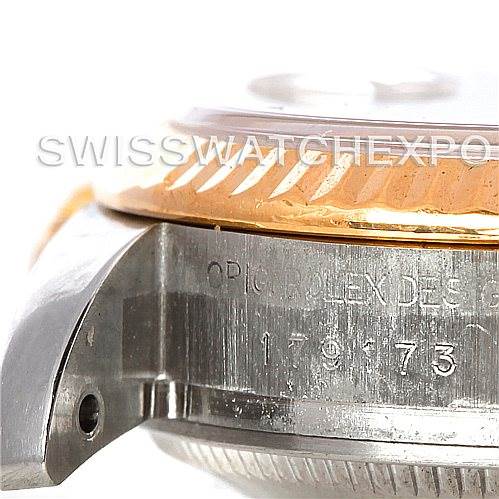 The image shows a close-up side view of a Rolex Datejust 179173SSJ Women's Steel and Gold (two tone) Champagne Dial 179173SSJ Women's Steel and Gold (two tone) Champagne Dial watch, focusing on the case and bezel with engraved details.