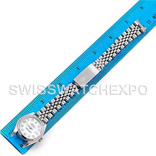 The image shows a top-down view of a Rolex Datejust 79174 Women's Stainless Steel White Dial 79174 Women's Stainless Steel White Dial watch, placed on a blue ruler, displaying its face and metal bracelet.