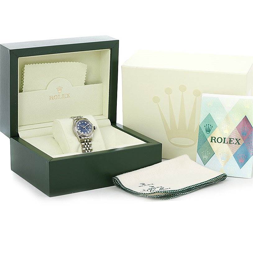 The image shows a Rolex Datejust 179174 Women's Stainless Steel Blue Dial 179174 Women's Stainless Steel Blue Dial watch in its green box, alongside a cleaning cloth and a Rolex booklet.