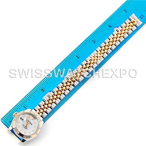 The image shows the Rolex Datejust 179313 Women's Stainless Steel Mother of Pearl Dial 179313 Women's Stainless Steel Mother of Pearl Dial watch from a top-down angle, highlighting the face and the two-tone bracelet placed next to a blue ruler.
