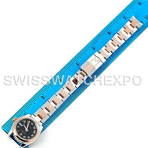 The image shows a Rolex Datejust 179161 Women's Steel and Gold (two tone) Black Dial 179161 Women's Steel and Gold (two tone) Black Dial watch laid flat next to a ruler, displaying the face and metal band.