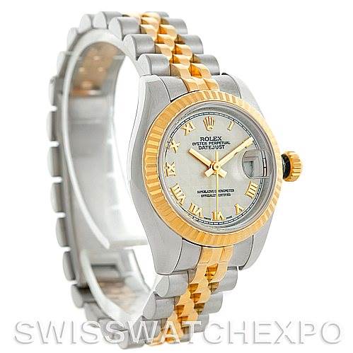 The Rolex Datejust 179173 Women's Steel and Gold (two tone) Beige Dial 179173 Women's Steel and Gold (two tone) Beige Dial watch is shown at an angled side view, highlighting its two-tone band, silver dial, and fluted gold bezel.