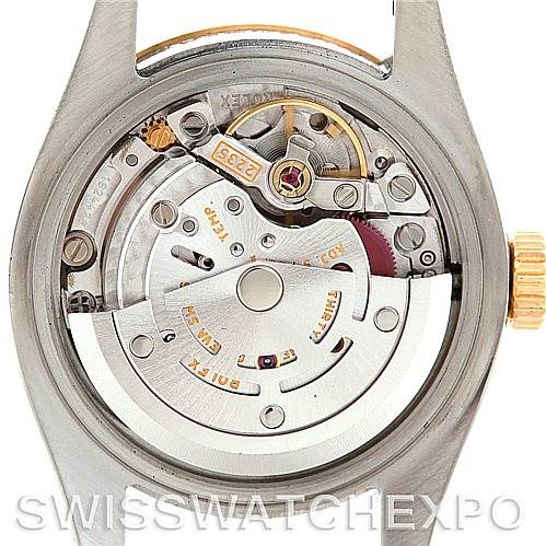 This image shows the movement mechanism of a Rolex Datejust 179173 Women's Steel and Gold (two tone) Beige Dial 179173 Women's Steel and Gold (two tone) Beige Dial watch from the back, including the rotor, gears, and balance wheel.