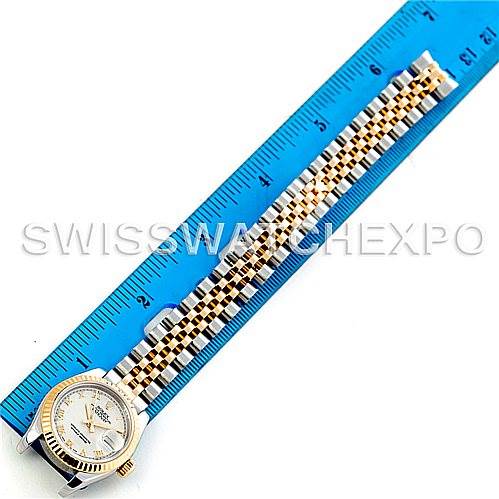 The image shows the Rolex Datejust 179173 Women's Steel and Gold (two tone) Beige Dial 179173 Women's Steel and Gold (two tone) Beige Dial watch laying flat against a blue ruler, with the full watch face and bracelet visible from above.