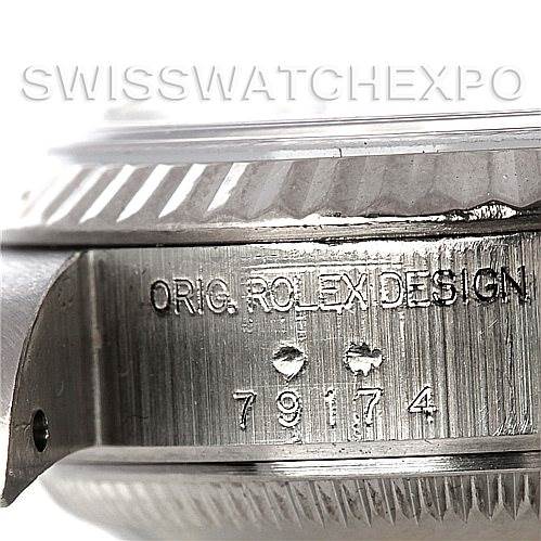 The image shows a close-up of the side of a Rolex Datejust 79174 Women's Stainless Steel Blue Dial 79174 Women's Stainless Steel Blue Dial watch case, displaying the model and serial number engravings.