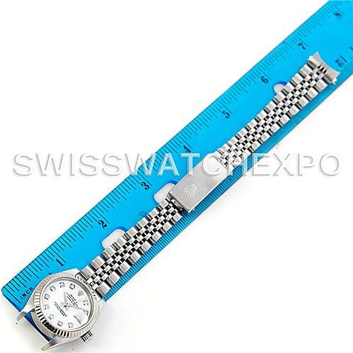 The image shows the Rolex Datejust 79174 Women's Stainless Steel White Dial 79174 Women's Stainless Steel White Dial watch laid flat alongside a ruler, highlighting its case, dial, and jubilee bracelet.