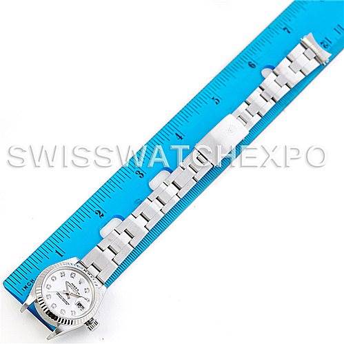 The image shows a top-down view of a Rolex Datejust 69174 Women
s Stainless Steel Mother of Pearl Dial 69174 Women
s Stainless Steel Mother of Pearl Dial watch with its bracelet placed next to a blue ruler for measurement.