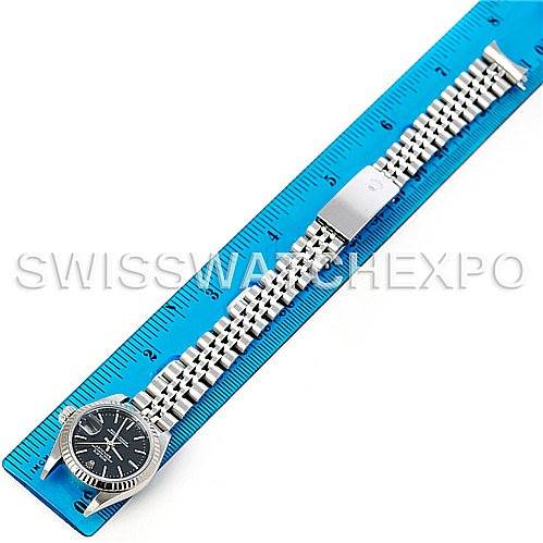 The Rolex Datejust 79174 Women's Stainless Steel Black Dial 79174 Women's Stainless Steel Black Dial watch is displayed flat from a top-down angle, showing the face, bezel, bracelet, and clasp alongside a blue ruler.