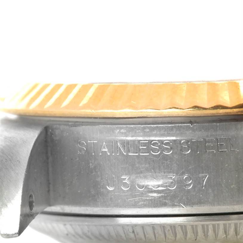 The image shows a close-up side view of the Rolex Datejust 69173 Women's Stainless Steel White Dial 69173 Women's Stainless Steel White Dial watch case, highlighting the stainless steel engraving and serial number.