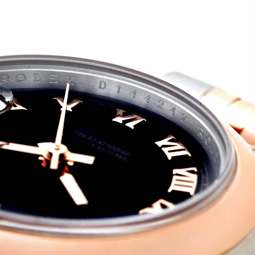 The image shows a close-up of the Rolex Datejust 179161 Women's Steel and Gold (two tone) Black Dial 179161 Women's Steel and Gold (two tone) Black Dial watch's dial, hands, and partial bezel with serial number engraving.