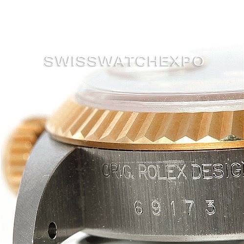 The image shows a close-up of the side of a Rolex Datejust 69173 Women
s Stainless Steel Beige Dial 69173 Women
s Stainless Steel Beige Dial watch, featuring part of the bezel, the crown, and the engraved model number 69173.