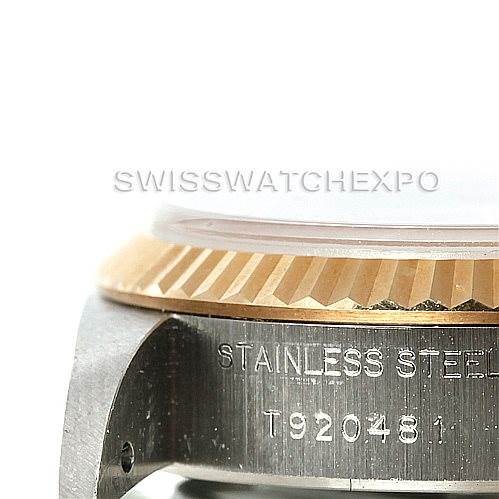 The image shows a close-up of the side of a Rolex Datejust 69173 Women
s Stainless Steel Beige Dial 69173 Women
s Stainless Steel Beige Dial watch, focusing on its bezel and part of the case with engraving.
