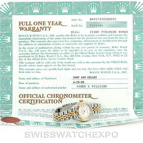 The image shows a Rolex Datejust 69173 Women
s Stainless Steel Beige Dial 69173 Women
s Stainless Steel Beige Dial watch and its warranty certificate from a top-down angle.