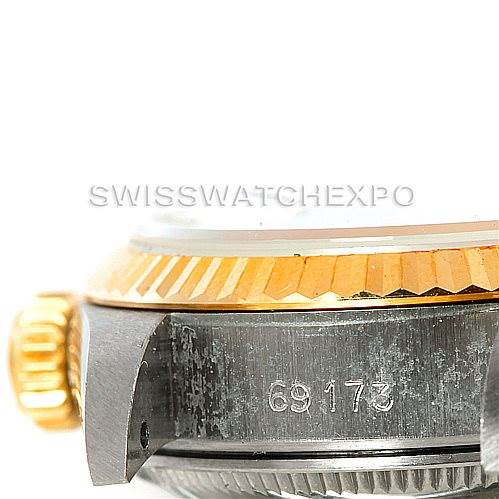 This image shows a close-up side view of a Rolex Datejust 69173 Women's Stainless Steel White Dial 69173 Women's Stainless Steel White Dial model, highlighting the crown, fluted bezel, and part of the case with the serial number.