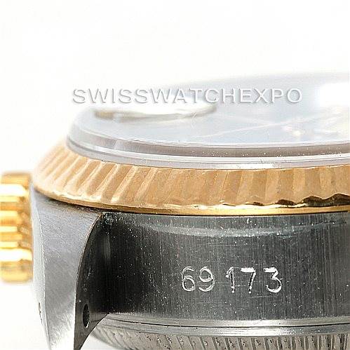 The image shows a side view of a Rolex Datejust 69173 Women's Stainless Steel Black Dial 69173 Women's Stainless Steel Black Dial watch, highlighting the bezel, crown, and part of the case with engraved numbers.