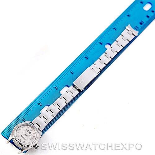 This image shows the Rolex Datejust 79174 Women's Stainless Steel Silver Dial 79174 Women's Stainless Steel Silver Dial watch laid flat next to a blue ruler, showcasing the entire band and face from a top-down angle.