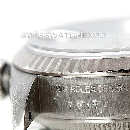The image shows a close-up angle of the Rolex Datejust 79174 Women's Stainless Steel Silver Dial 79174 Women's Stainless Steel Silver Dial watch case, highlighting the bezel and engraved serial number.