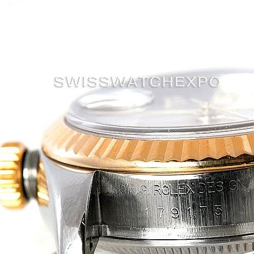 The image shows a close-up side view of a Rolex Datejust 179173 Women's Steel and Gold (two tone) Silver Dial 179173 Women's Steel and Gold (two tone) Silver Dial watch, highlighting the crown, bezel, and engraved serial numbers.