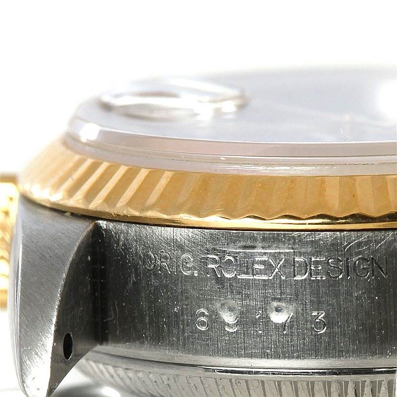 This image shows a close-up, side angle of a Rolex Datejust 69173 Women
s Stainless Steel Blue Dial 69173 Women
s Stainless Steel Blue Dial watch, highlighting the bezel and part of the case with engraved text.