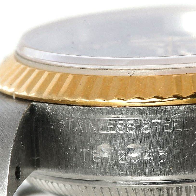 This close-up image of a Rolex Datejust 69173 Women
s Stainless Steel Blue Dial 69173 Women
s Stainless Steel Blue Dial watch shows the case side, serial engraving, and part of the bezel and crystal.