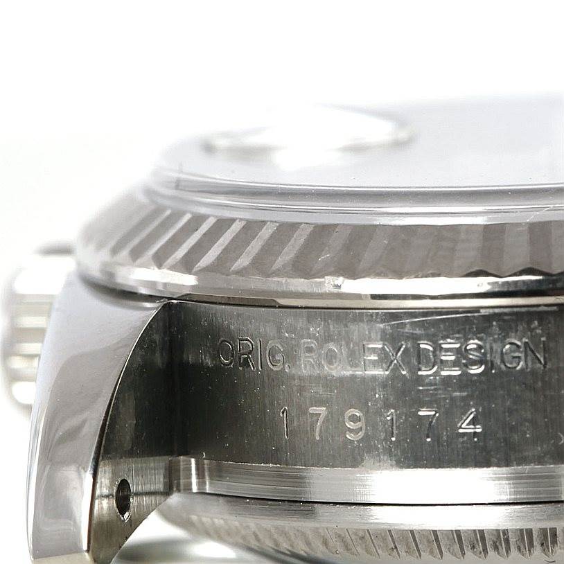 The image shows a close-up angle of the case body and fluted bezel of a Rolex Datejust 179174 Women's Stainless Steel Mother of Pearl Dial 179174 Women's Stainless Steel Mother of Pearl Dial, with visible engravings on the case.
