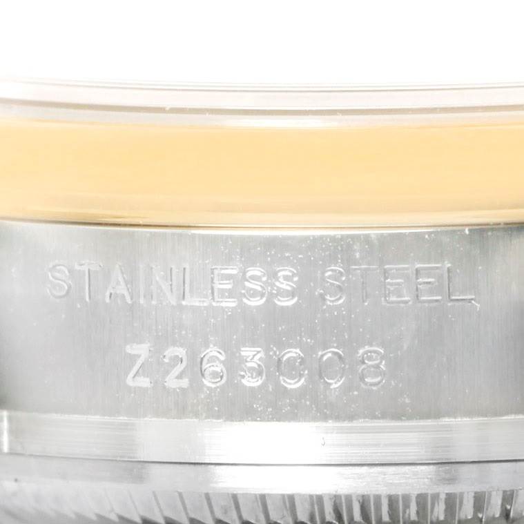 The image shows a close-up of the bezel and case side of a Rolex Datejust 179163 Women's Steel and Gold (two tone) White Dial 179163 Women's Steel and Gold (two tone) White Dial, indicating "Stainless Steel" and some alphanumeric characters.