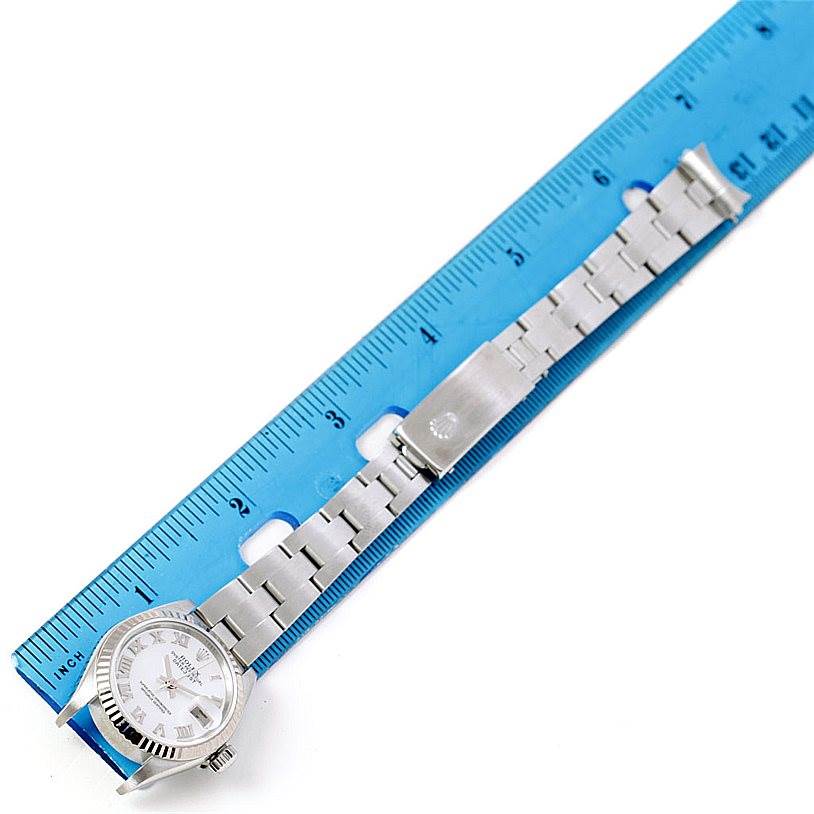 The image shows the face and bracelet of a Rolex Datejust 79174 Women's Stainless Steel Mother of Pearl Dial 79174 Women's Stainless Steel Mother of Pearl Dial watch, laid next to a blue measuring ruler.
