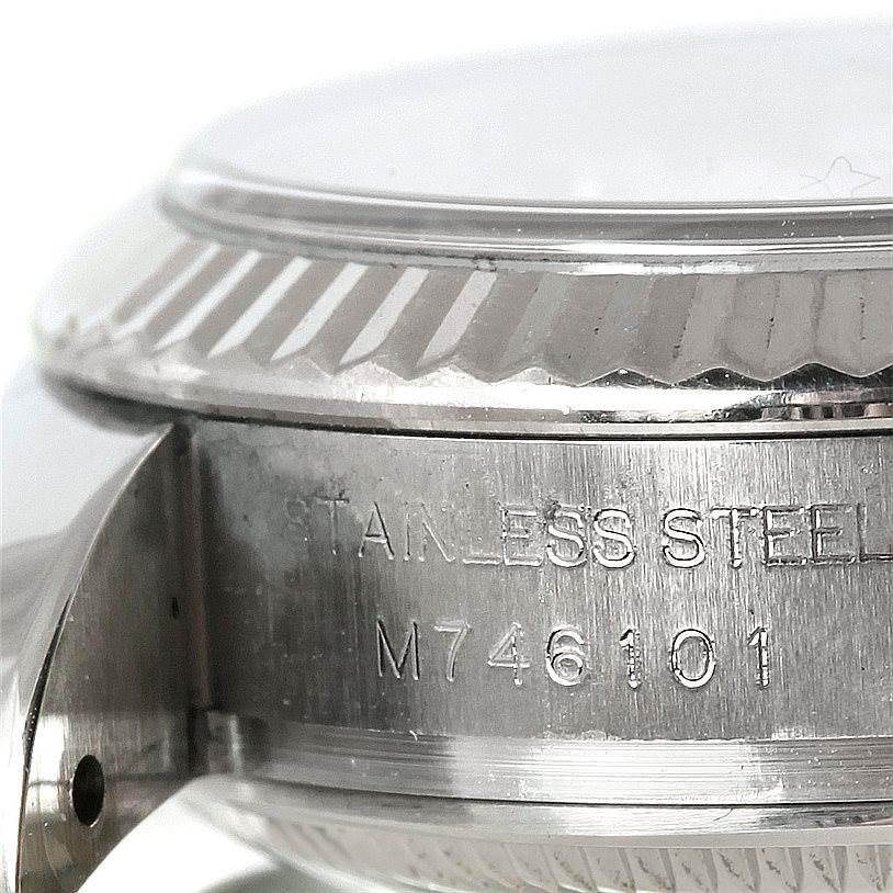 This close-up image of the Rolex Datejust 179174 Women's Stainless Steel Silver Dial 179174 Women's Stainless Steel Silver Dial watch shows the side of the stainless steel case and bezel, with visible serial numbers.