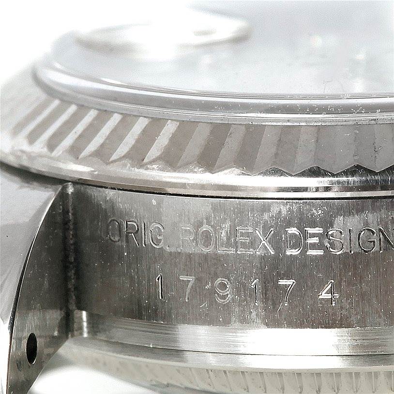This image shows a close-up view of the serial number and fluted bezel on a Rolex Datejust 179174 Women's Stainless Steel Silver Dial 179174 Women's Stainless Steel Silver Dial watch.