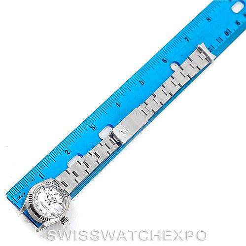 The image shows an aerial view of a Rolex Datejust 79174 Women's Stainless Steel White Dial 79174 Women's Stainless Steel White Dial watch alongside a ruler, highlighting the watch face and bracelet.