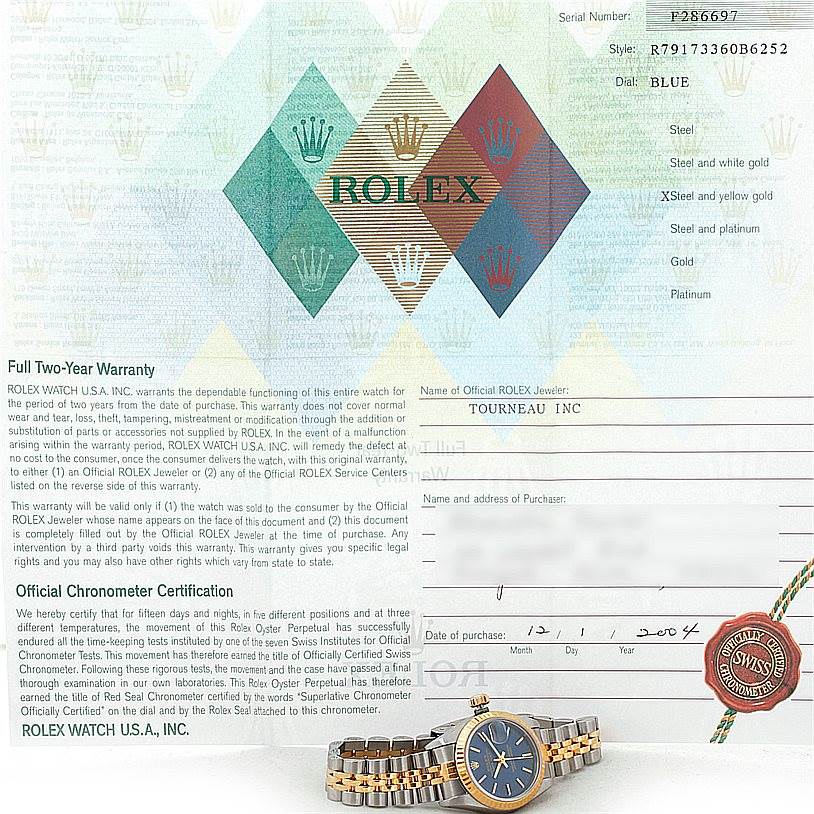 The image shows a Rolex Datejust 79173 Women's Stainless Steel Blue Dial 79173 Women's Stainless Steel Blue Dial model watch at a slight angle, with its warranty card and documentation in the background.