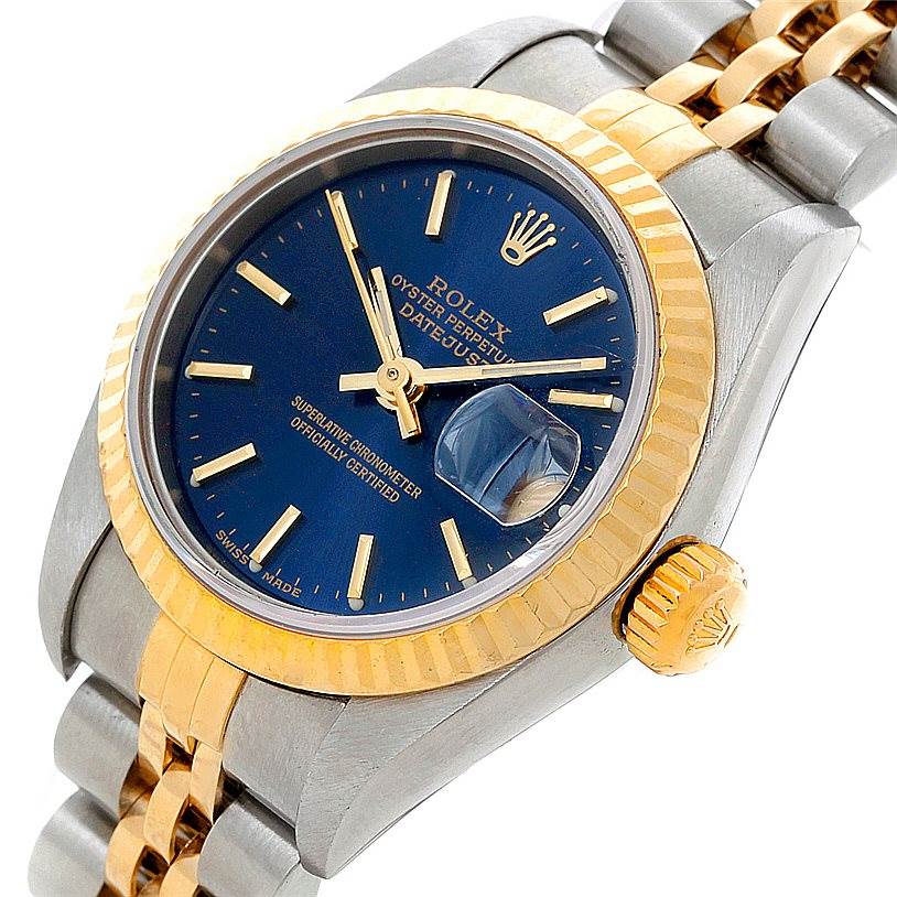 The Rolex Datejust 79173 Women's Stainless Steel Blue Dial 79173 Women's Stainless Steel Blue Dial model watch is shown at a three-quarter angle, highlighting its blue dial, gold bezel, and two-tone bracelet.