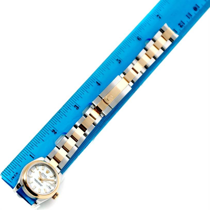 This image shows the Rolex Datejust 179163 Women's Steel and Gold (two tone) White Dial 179163 Women's Steel and Gold (two tone) White Dial watch from an overhead angle, featuring the watch face, bezel, and bracelet alongside a blue ruler.