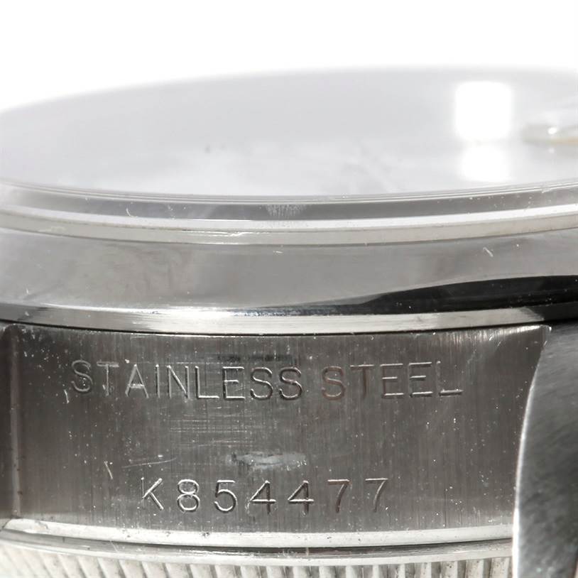 This image shows a close-up angle of the side of a Rolex Datejust 79160 Women's Stainless Steel White Dial 79160 Women's Stainless Steel White Dial watch case, highlighting the "STAINLESS STEEL" engraving and serial number.