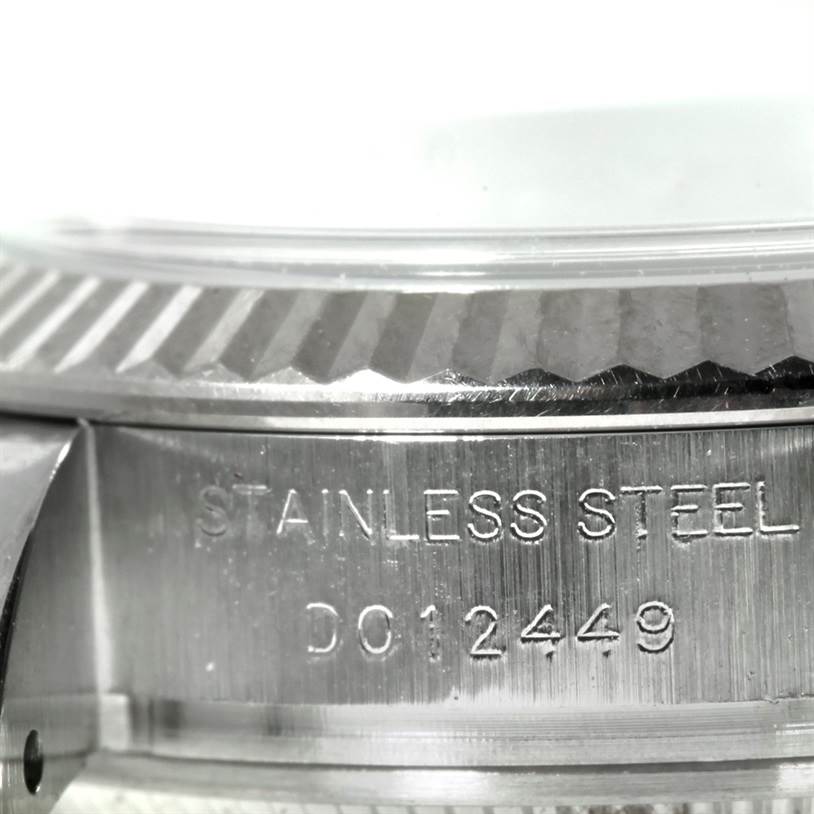 The image shows a close-up of the side case with a fluted bezel and engraving on a Rolex Datejust 179174 Women's Stainless Steel Mother of Pearl Dial 179174 Women's Stainless Steel Mother of Pearl Dial model watch.