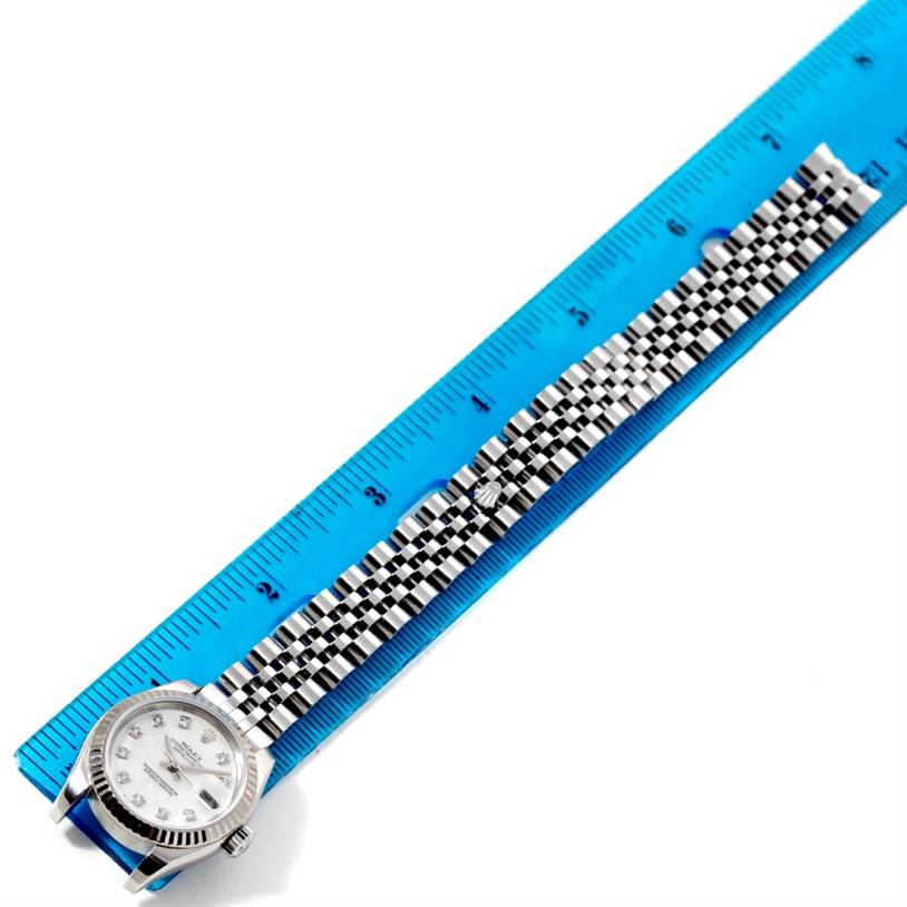 This overhead photo shows a Rolex Datejust 179174 Women's Stainless Steel Mother of Pearl Dial 179174 Women's Stainless Steel Mother of Pearl Dial watch with a silver jubilee bracelet, measured against a blue ruler.