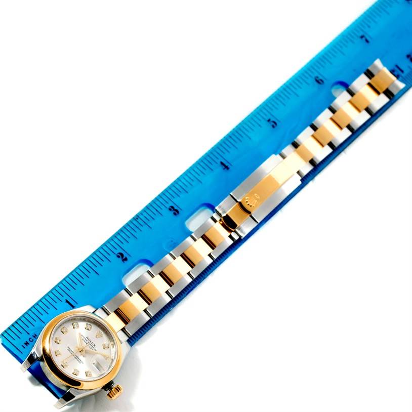 The image shows a Rolex Datejust 179163 Women's Steel and Gold (two tone) Silver Dial 179163 Women's Steel and Gold (two tone) Silver Dial watch laid flat next to a ruler measuring its length, highlighting the watch case, dial, and band.