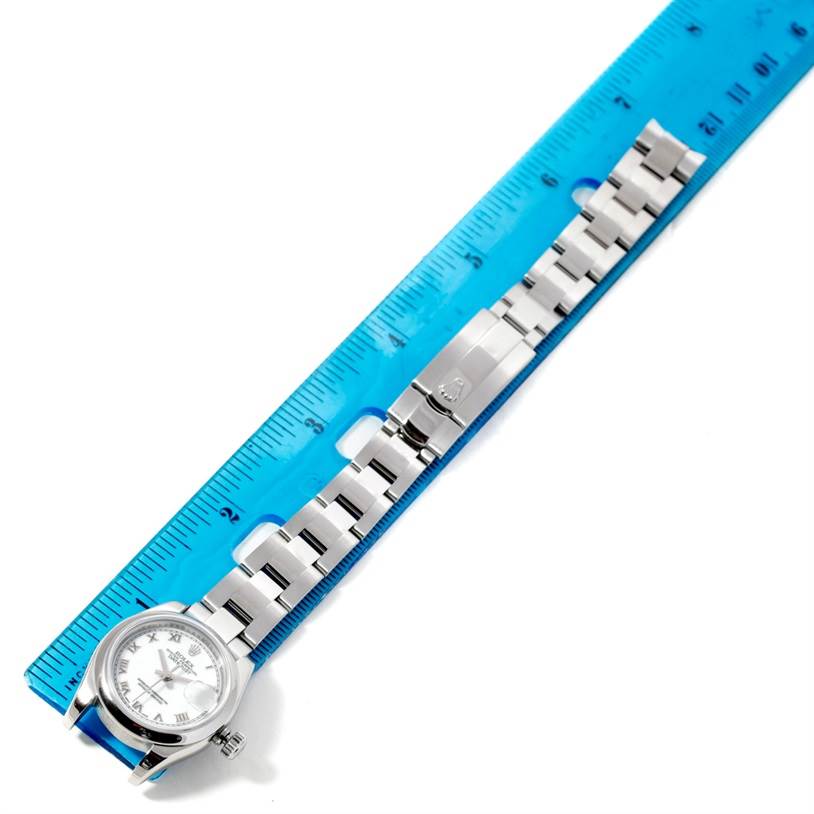 The image shows a Rolex Datejust 179160 Women's Stainless Steel White Dial 179160 Women's Stainless Steel White Dial watch laying flat beside a blue ruler, highlighting its bracelet and clasp.