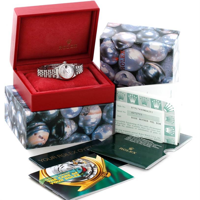 The image shows a Rolex Datejust 79174 Women's Stainless Steel Mother of Pearl Dial 79174 Women's Stainless Steel Mother of Pearl Dial watch with its box, warranty card, and manuals at a slight front, right angle.
