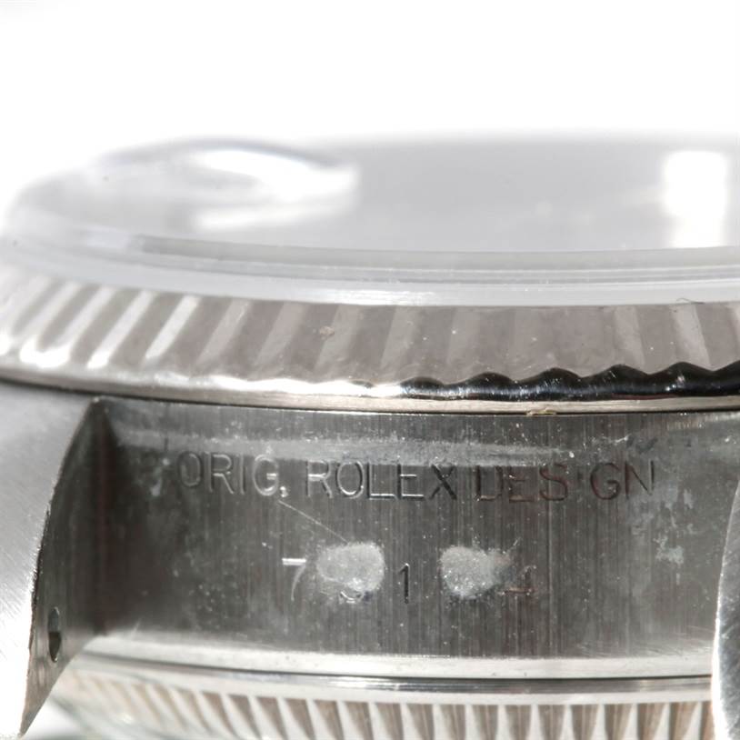 The image shows a close-up of the side of a Rolex Datejust 79174 Women's Stainless Steel Mother of Pearl Dial 79174 Women's Stainless Steel Mother of Pearl Dial watch case, specifically the edge of the bezel and part of the crystal.