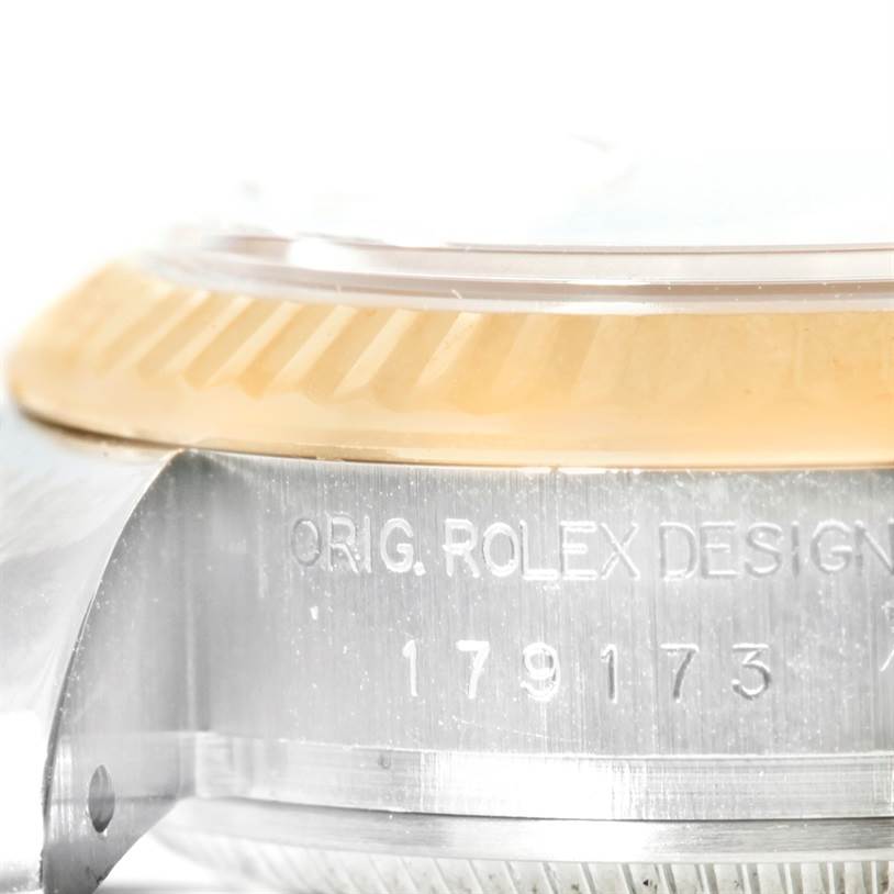This is a close-up angle showing the side of the Rolex Datejust 179173 Women
s Steel and Gold (two tone) White Dial 179173 Women
s Steel and Gold (two tone) White Dial watch case, focusing on its inscription and part of the bezel.