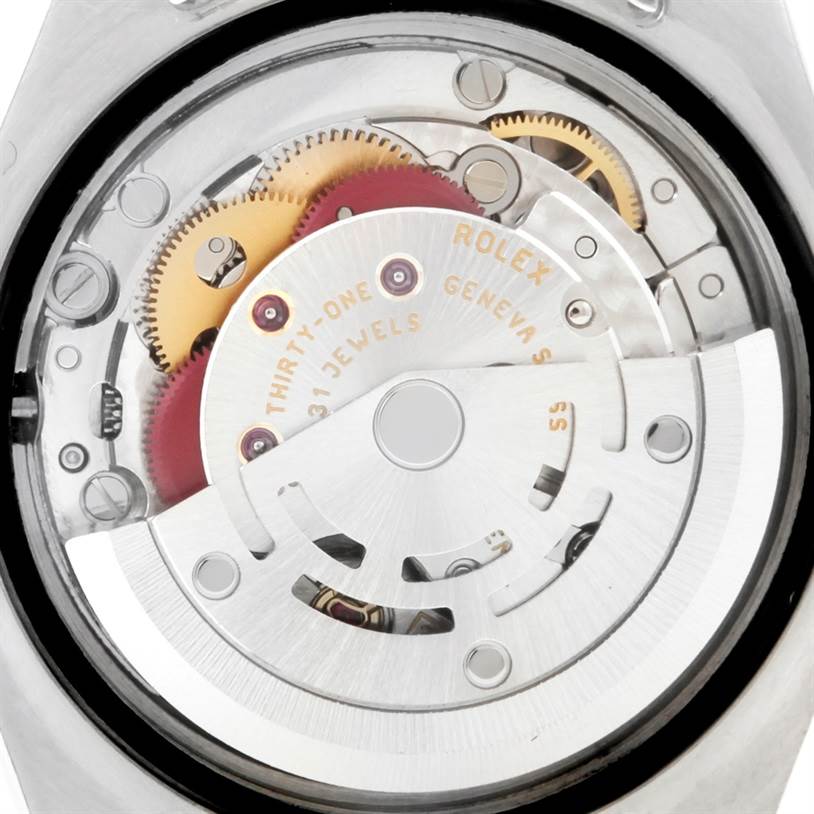 The image shows a close-up of the movement of a Rolex Datejust 179173 Women
s Steel and Gold (two tone) White Dial 179173 Women
s Steel and Gold (two tone) White Dial watch, highlighting the gears and mechanisms.