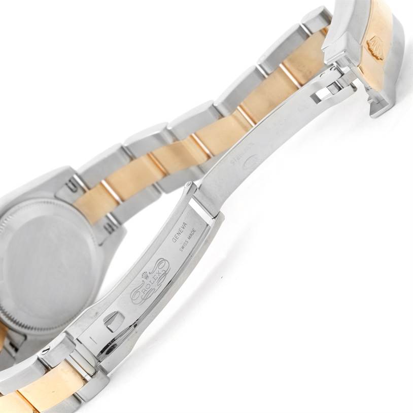 The image shows the underside of a Rolex Datejust 179173 Women
s Steel and Gold (two tone) White Dial 179173 Women
s Steel and Gold (two tone) White Dial watch with a focus on its clasp, links, and engraved details.