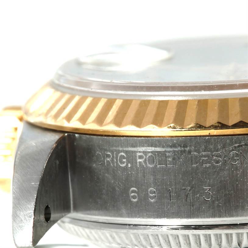The close-up angle shows the side of the Rolex Datejust 69173 Women
s Stainless Steel White Dial 69173 Women
s Stainless Steel White Dial case with the model number and part of the fluted bezel.