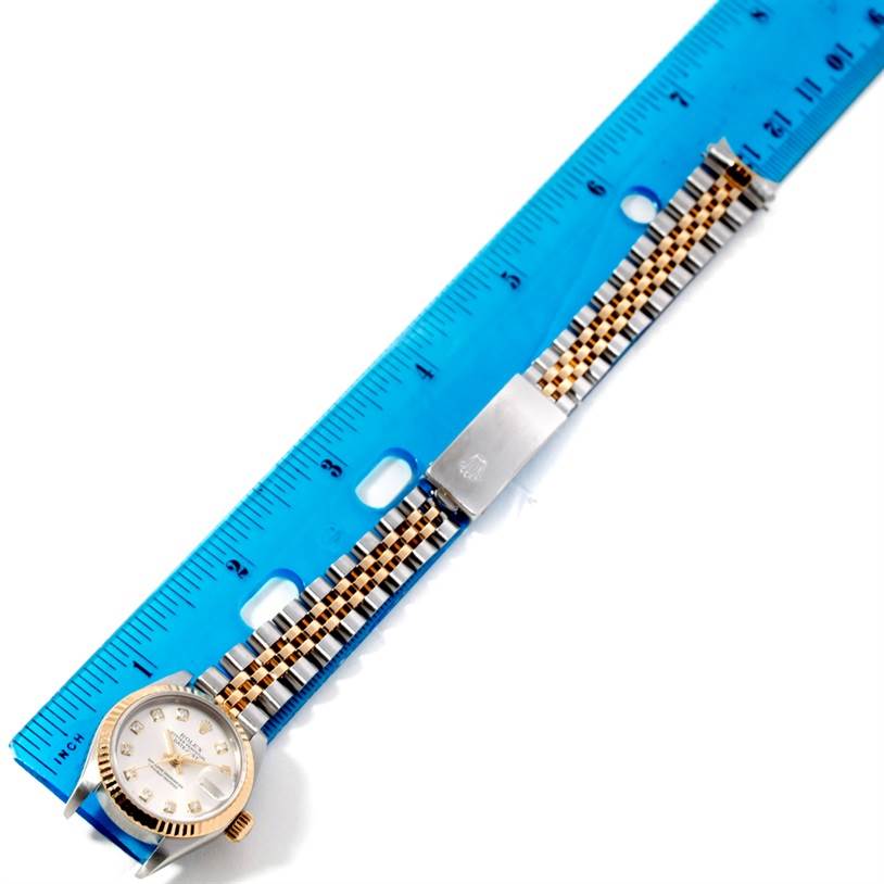 The image shows a Rolex Datejust 79173 Women's Stainless Steel Silver Dial 79173 Women's Stainless Steel Silver Dial watch laid flat against a ruler, highlighting its face, bracelet, and clasp from a top-down angle.