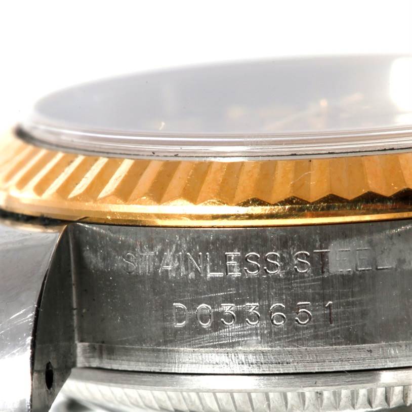 This close-up side angle of the Rolex Datejust 179173 Women's Steel and Gold (two tone) Champagne Dial 179173 Women's Steel and Gold (two tone) Champagne Dial shows part of the bezel, crystal, and stainless steel case with serial number.