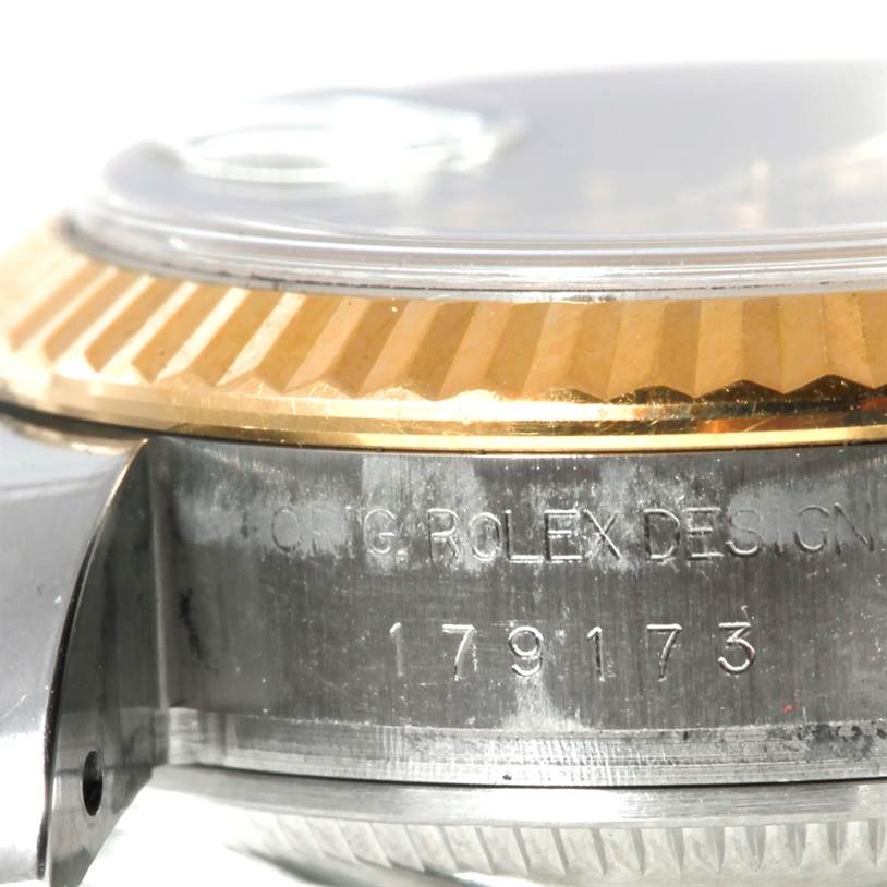 This image shows a close-up side view of a Rolex Datejust 179173 Women's Steel and Gold (two tone) Champagne Dial 179173 Women's Steel and Gold (two tone) Champagne Dial watch, focusing on the case and engraved details.